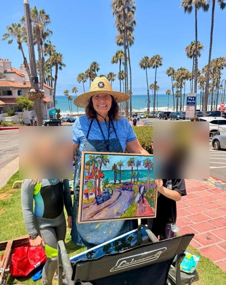 Susan Kendall holding a sold Calafia Beach painting in San Clemente; children in the photo are blurred for privacy.
